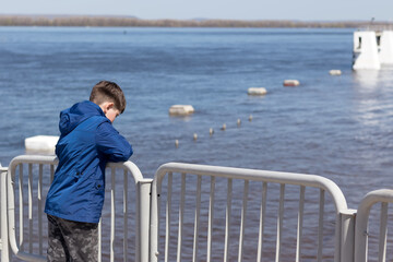 Dream. the child dreams of standing on the pier near the water and looking at the opposite shore