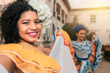 Two traditional dancers wearing the typical costume of Nicaragua smiling and looking at the camera at sunset. The dress is similar to those of other South American and Central American - obrazy, fototapety, plakaty