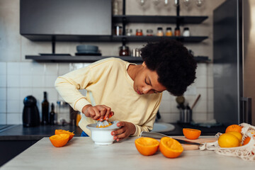 Fototapeta na wymiar Teenage girl squeezing orange, making juice