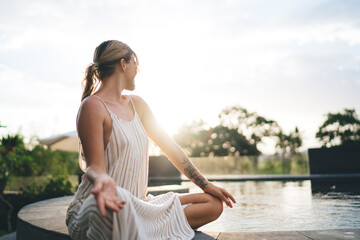 Girl practice yoga and meditate near swimming pool