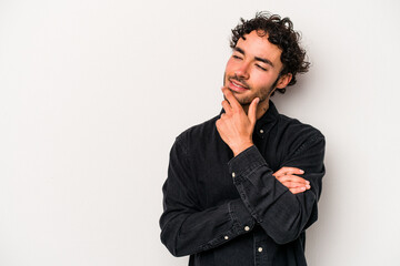 Young caucasian man isolated on white background relaxed thinking about something looking at a copy space.