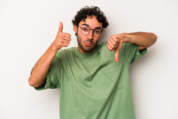 Young caucasian man isolated on white background showing thumbs up and thumbs down, difficult...