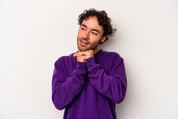 Young caucasian man isolated on white background praying for luck, amazed and opening mouth looking to front.