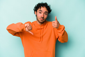 Young caucasian man isolated on white background showing thumbs up and thumbs down, difficult...