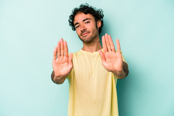 Young caucasian man isolated on white background standing with outstretched hand showing stop sign, preventing you.