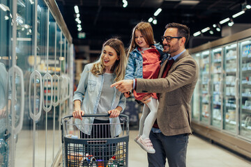 Father pointing to daughter favorite food in supermarket