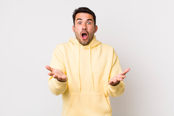 young handsome hicpanic man open-mouthed and amazed, shocked and astonished with an unbelievable...