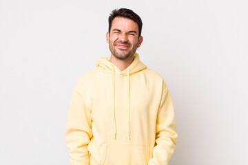 young handsome hicpanic man looking happy and friendly, smiling and winking an eye at you with a...