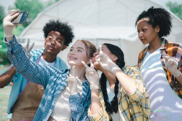 A group of teenagers using smartphones to take selfies. Group of young people using mobile phone to take a selfie together. Group of friends having fun. Cheerful friends.
