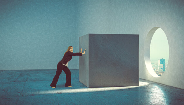woman pushes cube concrete block