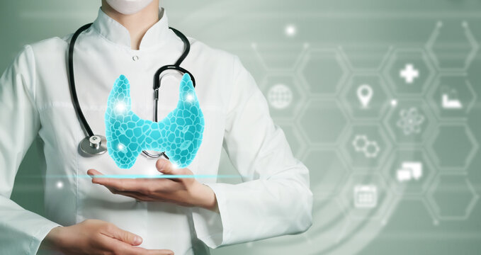 Unrecognizable female doctor holding graphic virtual visualization model of Thyroid Gland organ in hands. Multiple medical icons on the background.