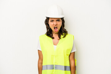 Young laborer hispanic woman isolated on white background screaming very angry and aggressive.