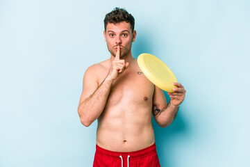 Young caucasian man playing with frisky isolated on blue background keeping a secret or asking for...