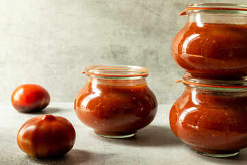 Homemade tomato puree in glass jars. Preserving own organic vegetables.