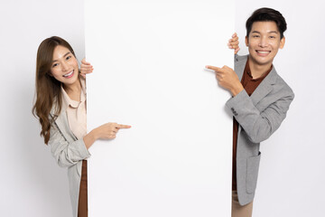 Asian businessman and businesswoman pointing and holding blank white billboard isolated on white...