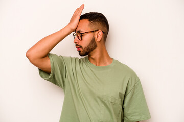 Young hispanic man isolated on white background forgetting something, slapping forehead with palm...