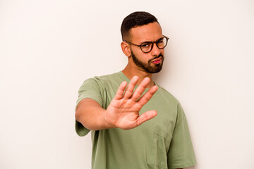 Young hispanic man isolated on white background rejecting someone showing a gesture of disgust.