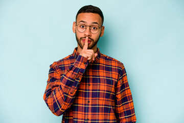 Young hispanic man isolated on blue background keeping a secret or asking for silence.