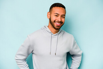 Young hispanic man isolated on blue background happy, smiling and cheerful.