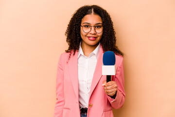 Young African American TV presenter woman isolated on beige background happy, smiling and cheerful.