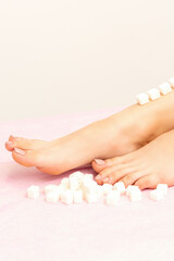 Obraz na płótnie Canvas The concept of epilation, waxing. Sugar cubes lie down in a row on the naked white female leg
