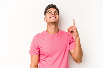 Young caucasian man isolated on white background indicates with both fore fingers up showing a...
