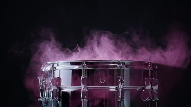  Playing drums with colorful pink powder close-up. Drummer playing musical instrument, professional musician player. 