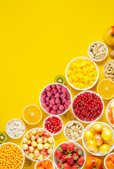 Berries, fruits and nuts on a yellow background. Vegetarian food. Copy space