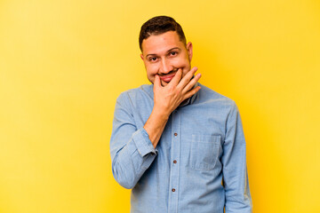 Young hispanic man isolated on yellow background doubting between two options.