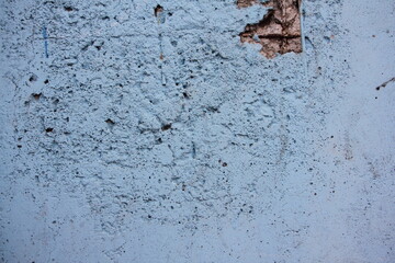 Old wall with collapsed blue plaster. Repair of an old fence. Industrial-style wall background.