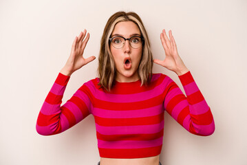 Young caucasian woman isolated on white background celebrating a victory or success, he is surprised and shocked.