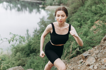 Exercising outdoors is healthy for active lifestyle runners. Autumn trail run woman running in nature near lake. Outdoor jog.