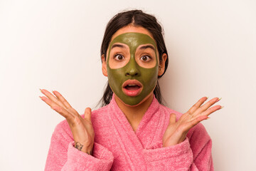 Young hispanic woman wearing a facial mask isolated on white background surprised and shocked.