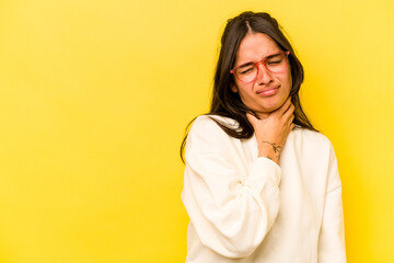 Young hispanic woman isolated on yellow background touching back of head, thinking and making a...