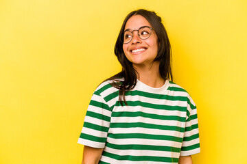 Young hispanic woman isolated on yellow background relaxed and happy laughing, neck stretched showing teeth.