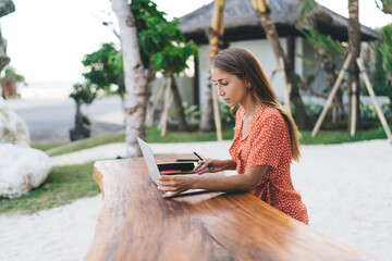 Caucaisan female freelancer browsing web information on modern laptop computer working remotely...
