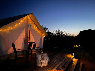 Glamping tent with lights at sunset 