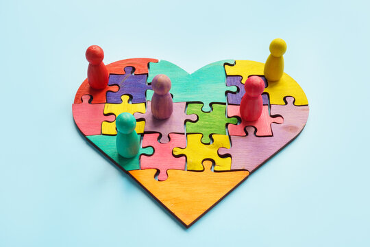 Togetherness and inclusion. Puzzle heart and colored figurines.