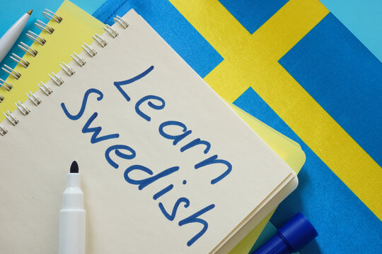 Learn Swedish. Open notebook, pen and flag.