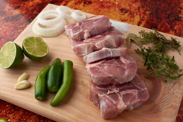 Pork for tacos, knuckle, around there are serrano peppers, garlic, onion, oregano, thyme and bay...