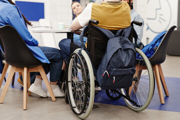 Back view at young college student in wheelchair participating in group discussion, copy space