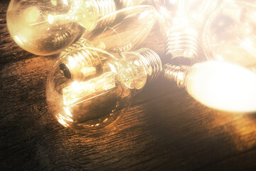 Glowing warm light bulbs on wooden surface