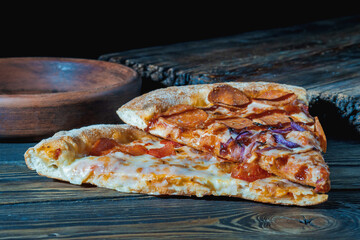 Fresh slices of pizza on a wooden background. Close-up.
