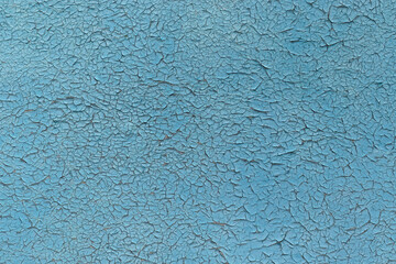 Old blue cracked paint on a metal panel.