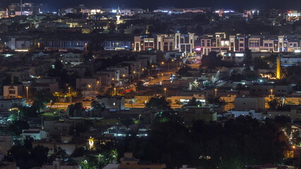 Fototapeta premium Aerial view of apartment houses and villas in Dubai city night timelapse, United Arab Emirates