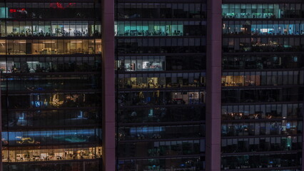 Fototapeta na wymiar Big glowing windows in modern office and residential buildings timelapse at night