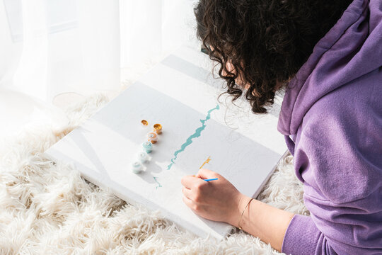 The adult woman painting by numbers indoors