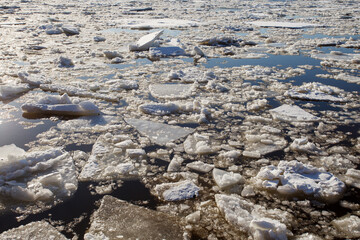 Ice on the river, ice drift and pieces of split ice on the water.