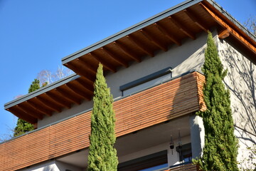 Balkon mit Metall-Geländer und lasierten Holzplanken an einem Wohnhaus