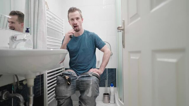 Bathroom invasion of privacy with man on toilet washing teeth multitasking 4K
